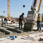 NAGA2000 concrete product being poured on a construction site with skilled workers and machinery.
